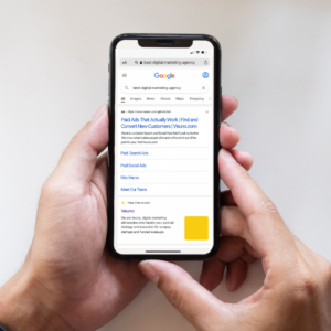 A photo of someone holding a mobile phone showing a Google ad for Veuno