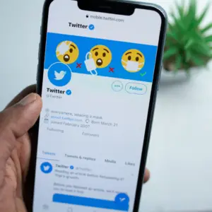 Man using Twitter on his mobile phone - Twitter Ad Specs for 2024