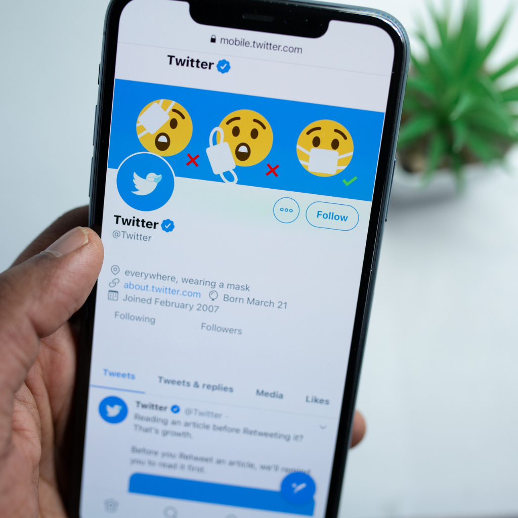 Man using Twitter on his mobile phone - Twitter Ad Specs for 2022