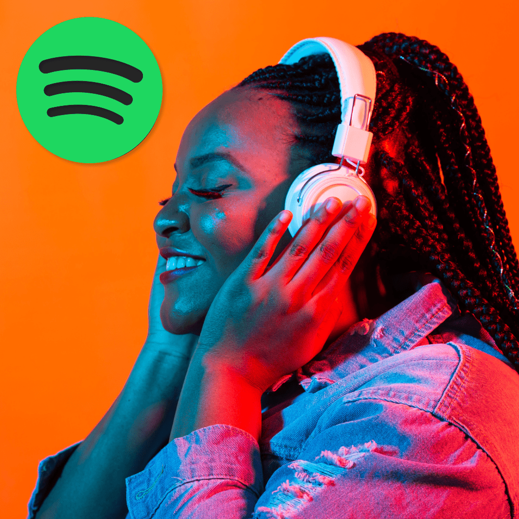 Black twenty something woman listening to music through a pair of white over ear headphones with her eyes closed, a smile across her lips, lost in the music. Also includes the Spotify logo for the Spotify Ad Specs for 2024 blog post.