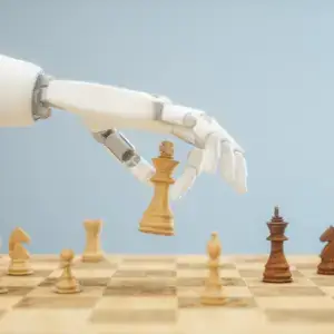 Robot hand playing a move on a wooden chessboard.