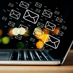 Photo of an open laptop with email envelopes drawn flying out of the screen.
